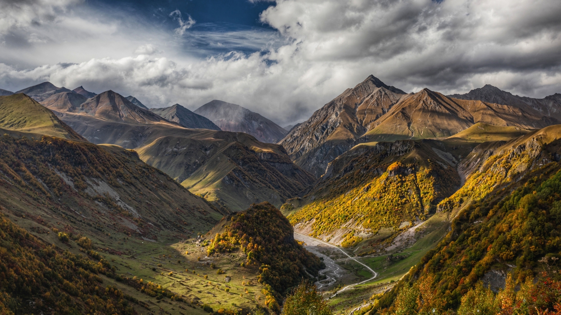 Captivating autumn mountain landscape in Gudauri, showcasing vibrant fall colors and rugged peaks.