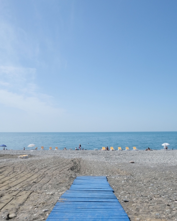 Idyllic Batumi beachfront with sunbeds, umbrellas, and a serene blue sky over the Black Sea.