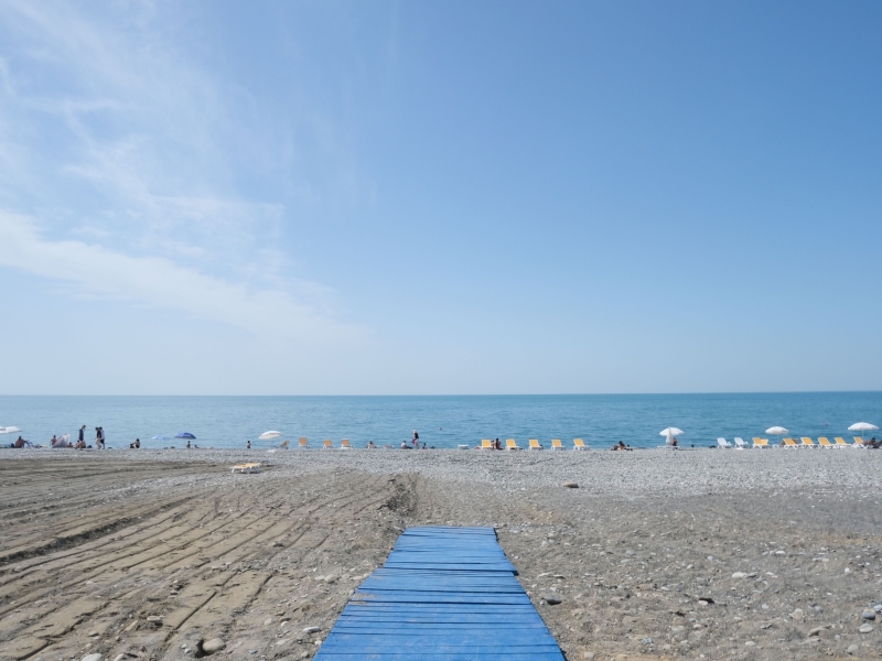 Idyllic Batumi beachfront with sunbeds, umbrellas, and a serene blue sky over the Black Sea.