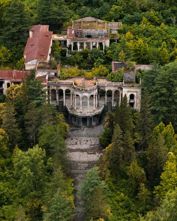 Explore the haunting beauty of the abandoned sanatorium in Tskaltubo, surrounded by lush greenery.
