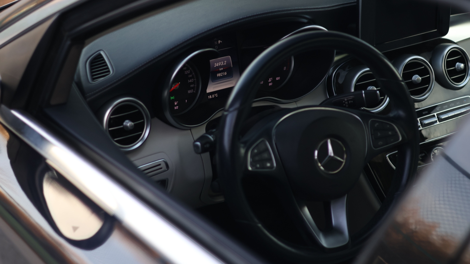 Close-up of a luxury car's interior showcasing modern dashboard and steering wheel.