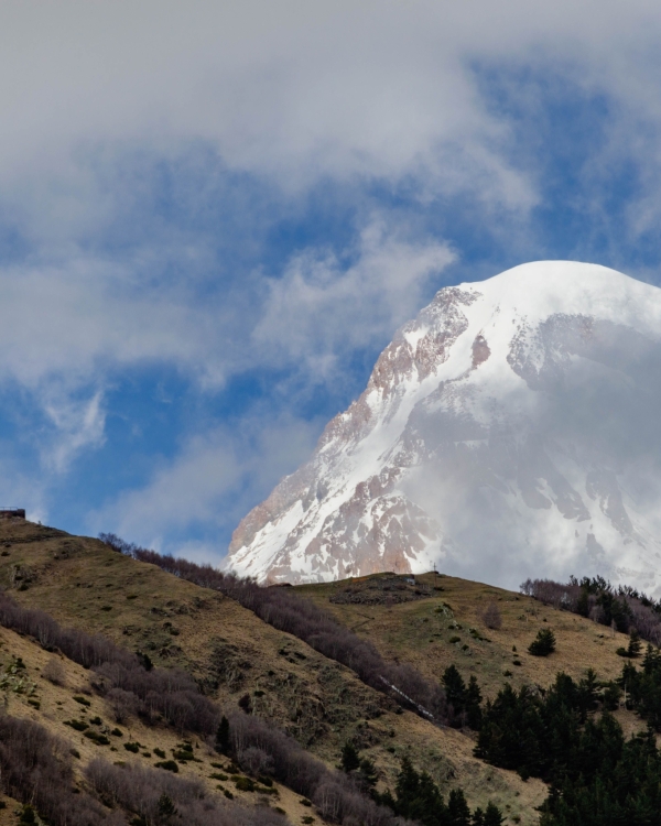 Scenic view of Gergeti Trinity Church with Mount Kazbegi in the background, Georgia's majestic landscape.